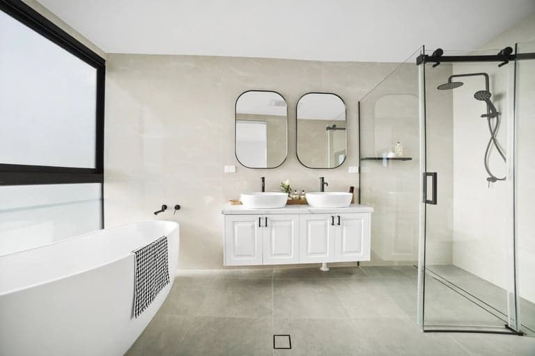 Double vanity bathroom renovation in Sydney with black mirrors and a glass shower