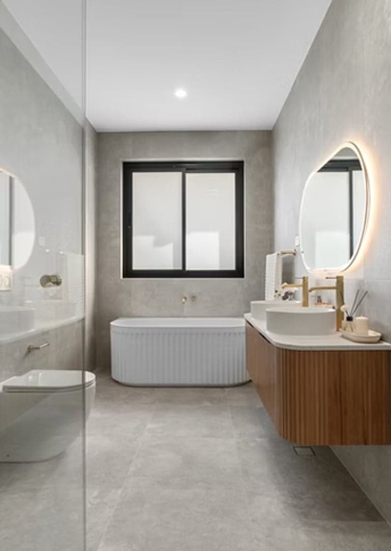 Sydney bathroom renovation with an oak vanity, gold tapware and ribbed freestanding bath