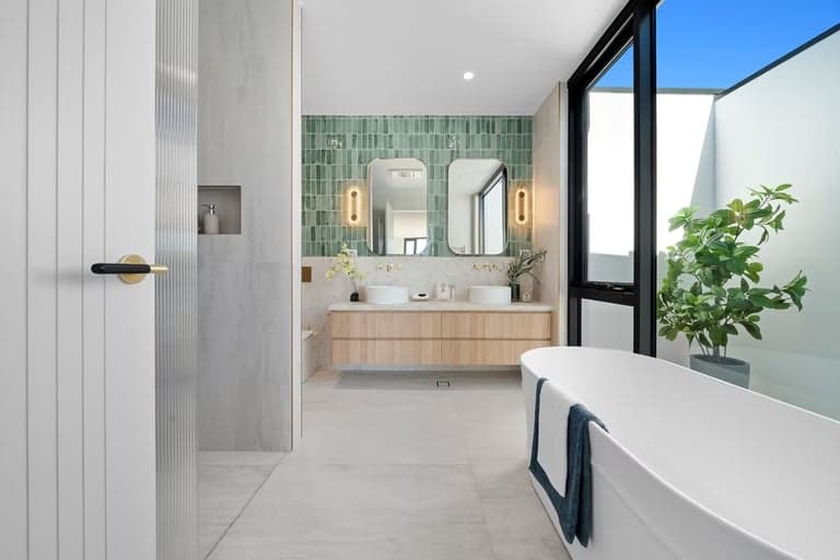 Bright Sydney bathroom with an oak vanity, mint tiles and a freestanding bath
