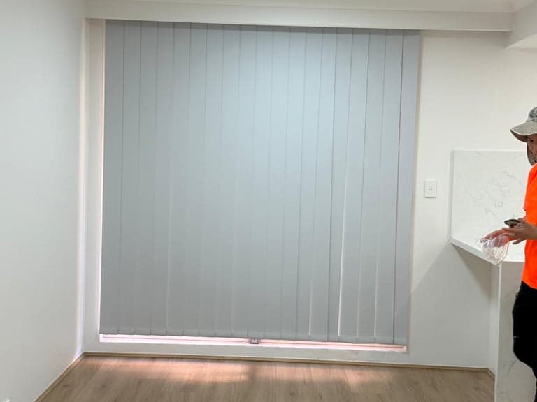 Closed white vertical blinds for privacy in a Sydney living space