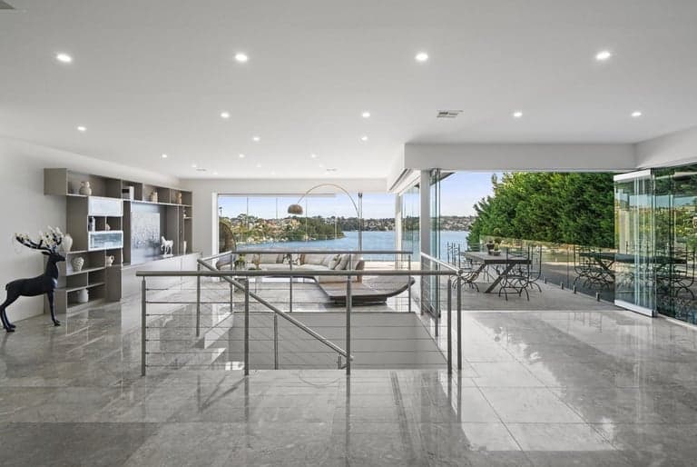 Polished stone flooring in a Sydney living room opening to harbour views