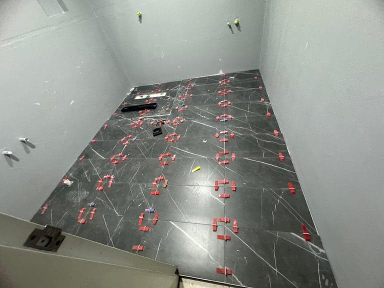 Black marble floor tiles being laid in a Sydney wet-area renovation