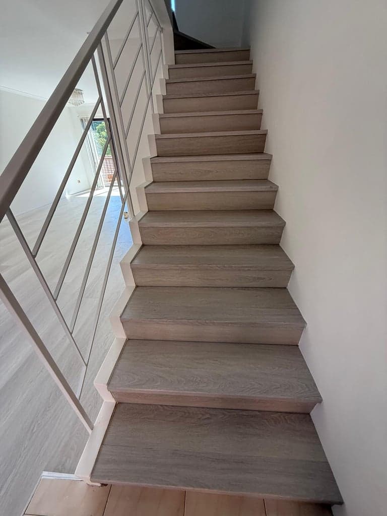 Matching grey oak stair treads and landing flooring in a Sydney home