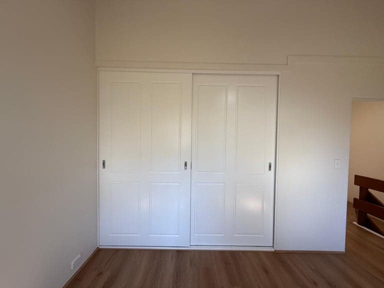 White shaker sliding wardrobe doors installed in a Sydney bedroom