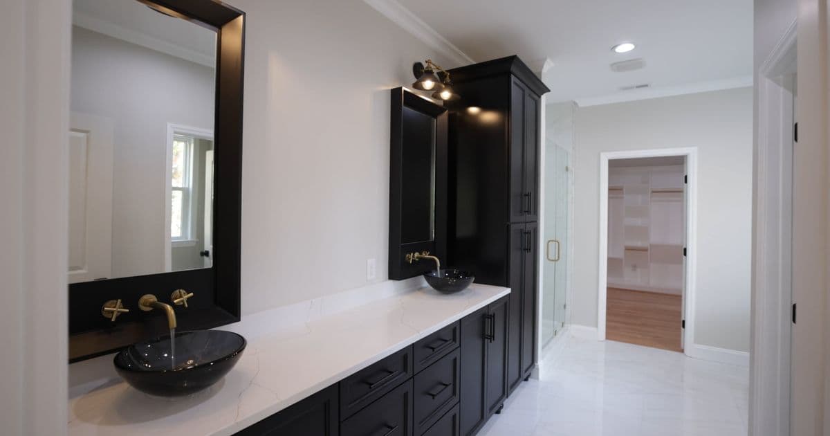 Black vanity bathroom renovation with marble benchtops and brass tapware