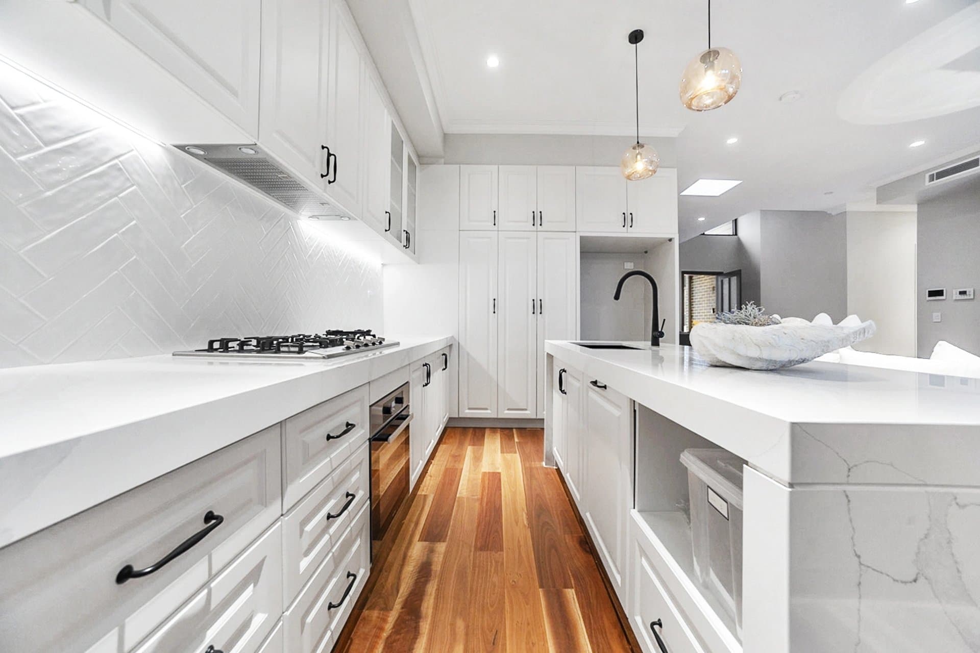White shaker kitchen renovation in Sydney with herringbone splashback and timber floors