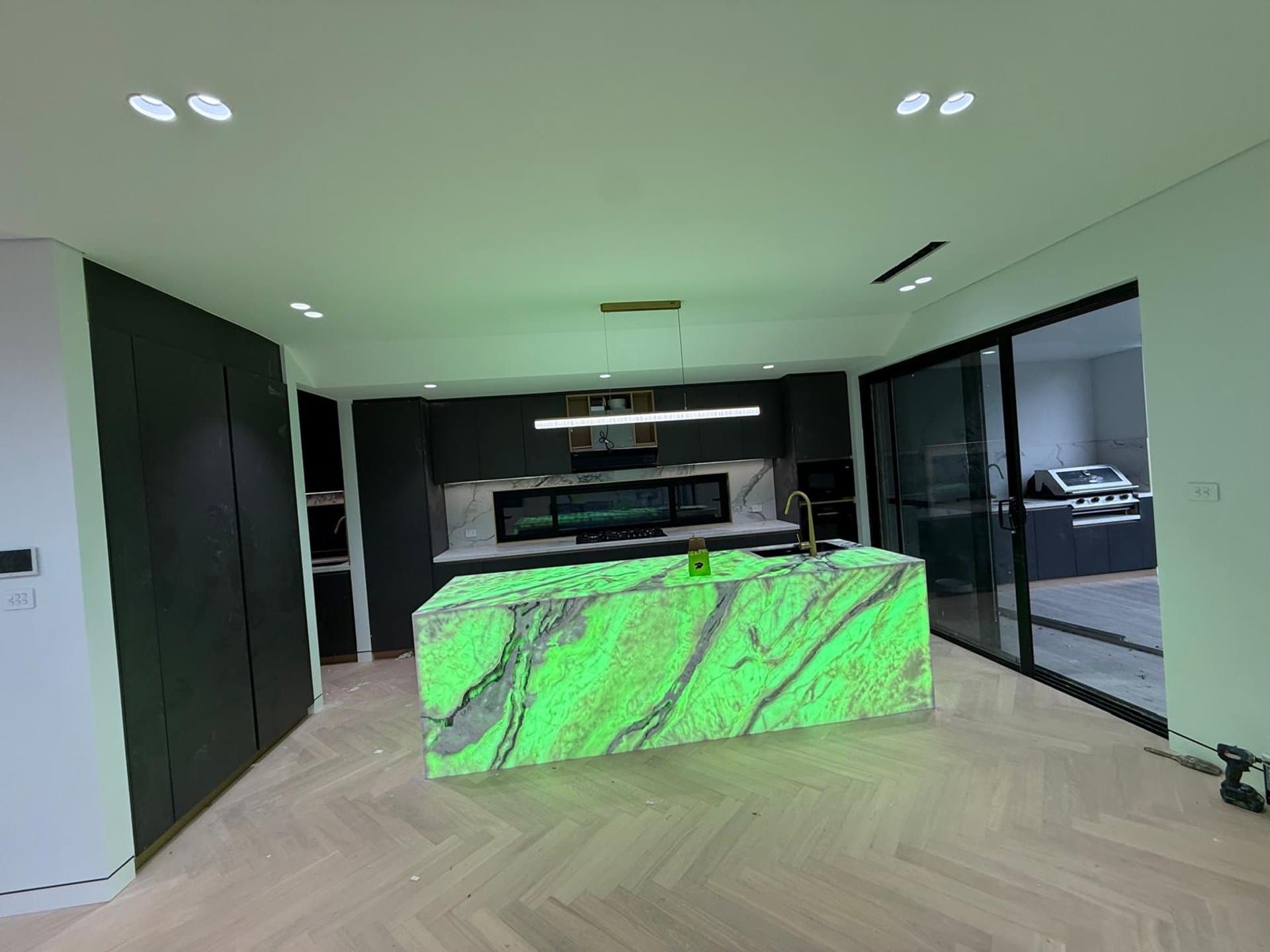 Kitchen island with a statement marble benchtop and dark cabinetry in Sydney