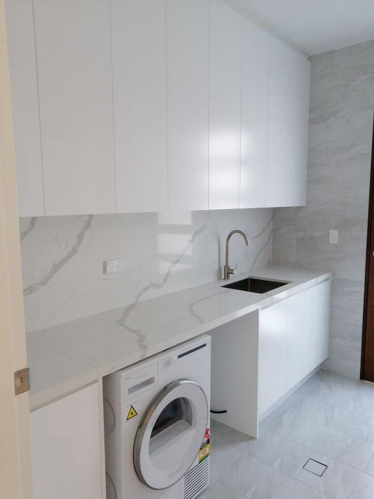 Sydney laundry with white stone surfaces and custom storage